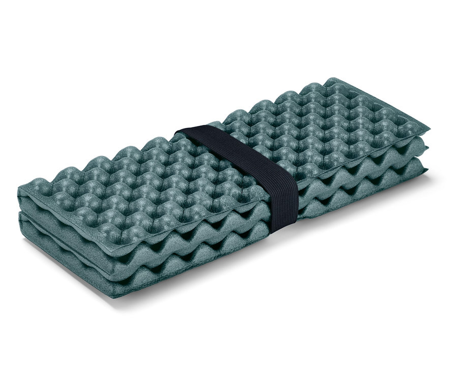 Tapis de sol pliable vert olive avec motif à picots, maintenu par un élastique noir.