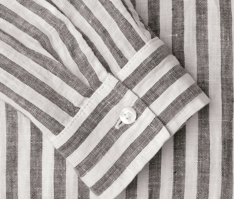 Gros plan d'une chemise rayée avec un bouton sur la manche.