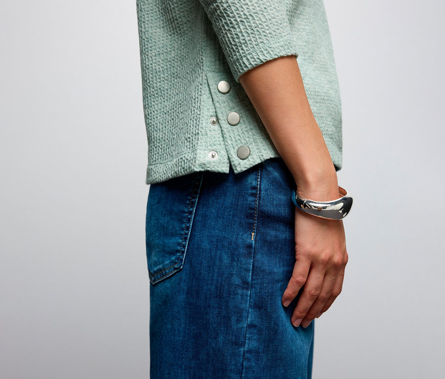 Gros plan d'une femme portant un maillot avec structure Street One et une jupe en jean.