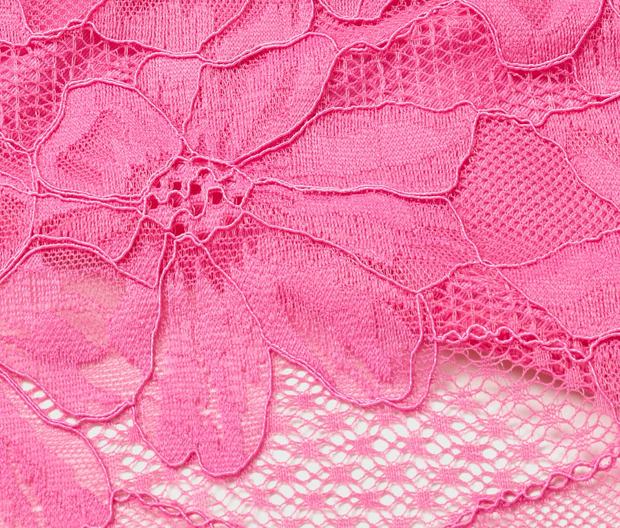 Gros plan sur de la dentelle rose à motif floral.