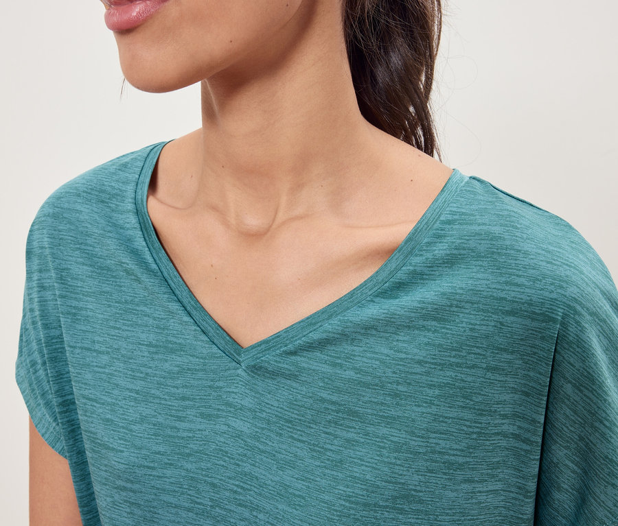 Gros plan d'une femme portant un t-shirt turquoise à col en V.