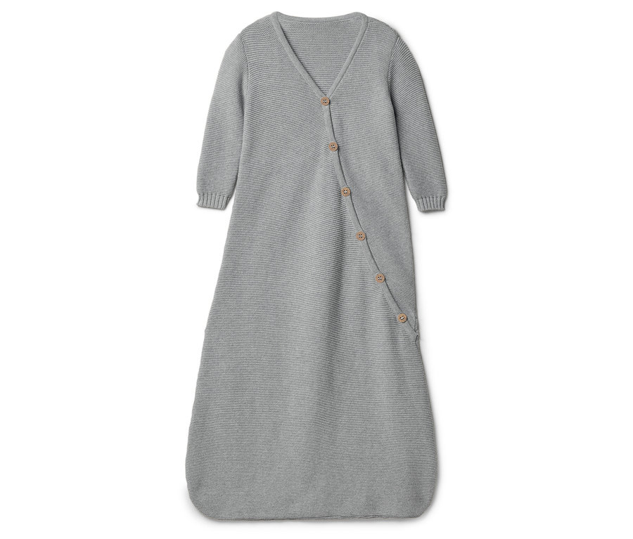 Gigoteuse grise tricotée pour bébé avec des boutons sur fond blanc.