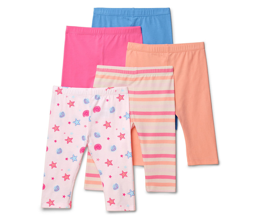 Cinq leggings sont posés les uns sur les autres, dont une paire à motifs d'étoiles de mer et de coquillages, une paire rayée et trois paires unies : bleue, rose et orange.