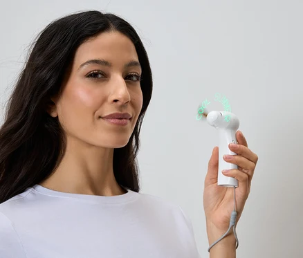 Une femme tient un ventilateur portable blanc qui affiche les mots "Cool Summer".