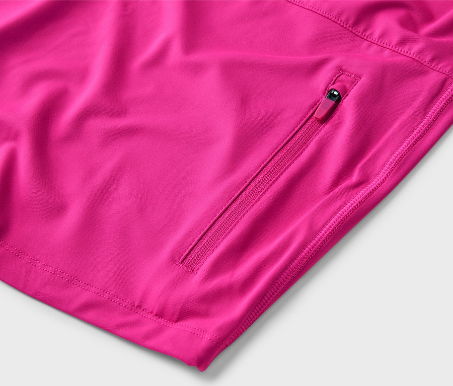 Gros plan sur une veste rose avec une poche zippée.