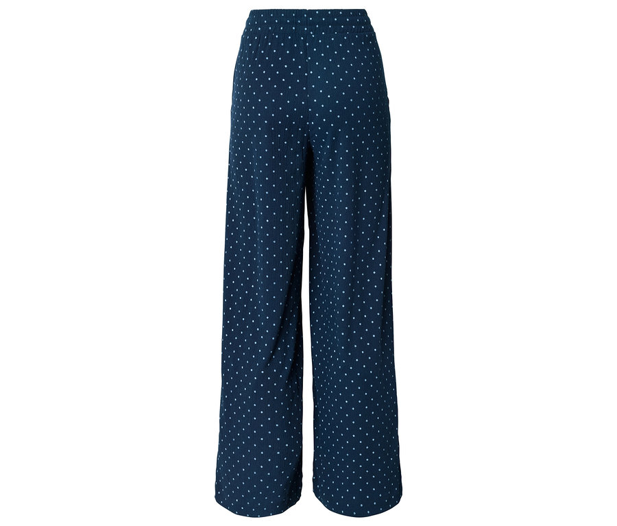 Pantalon marine à coupe large avec des pois blancs sur fond blanc.