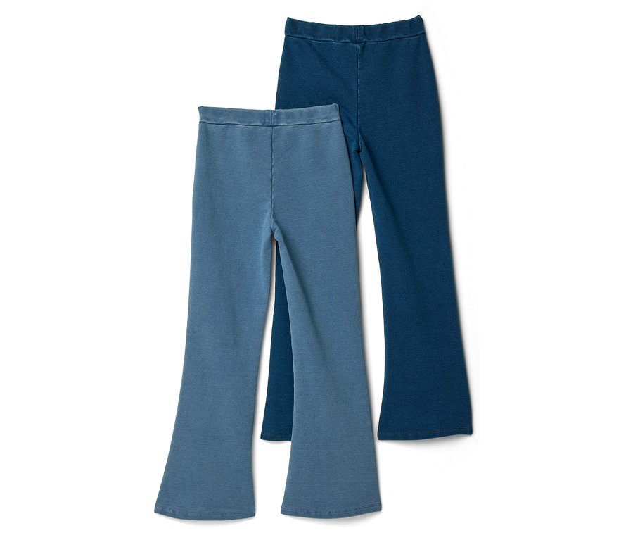 Deux pantalons évasés bleus sont superposés sur un fond blanc.
