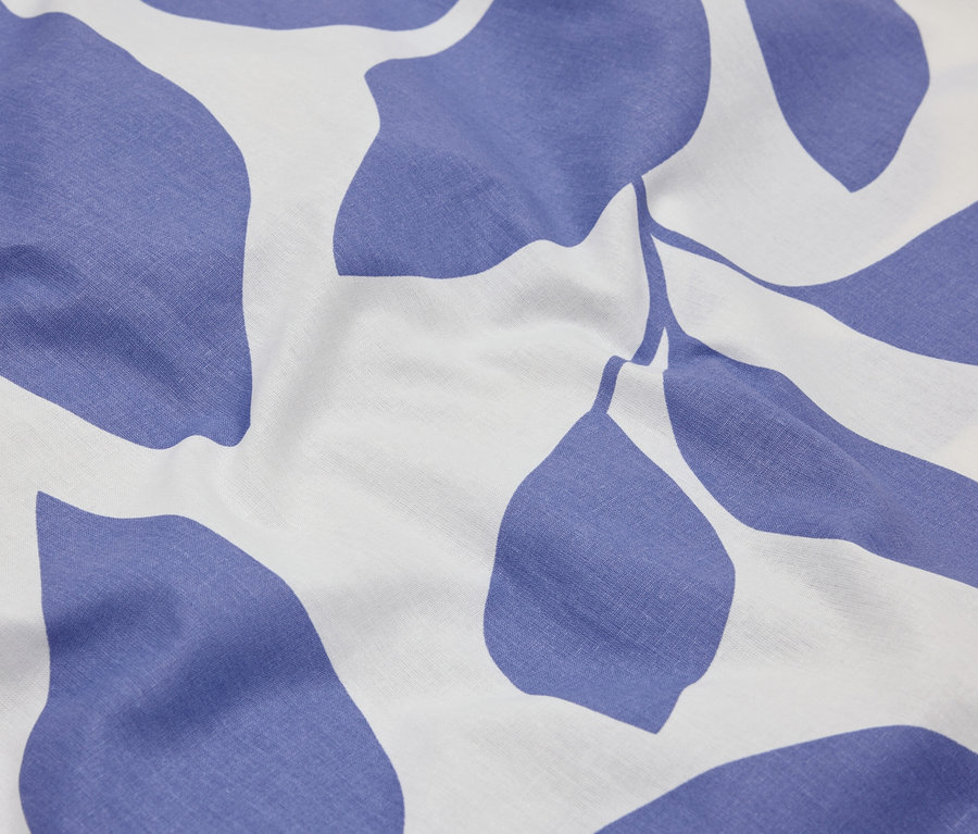 Gros plan d'un tissu avec un motif de feuilles bleues sur fond blanc.