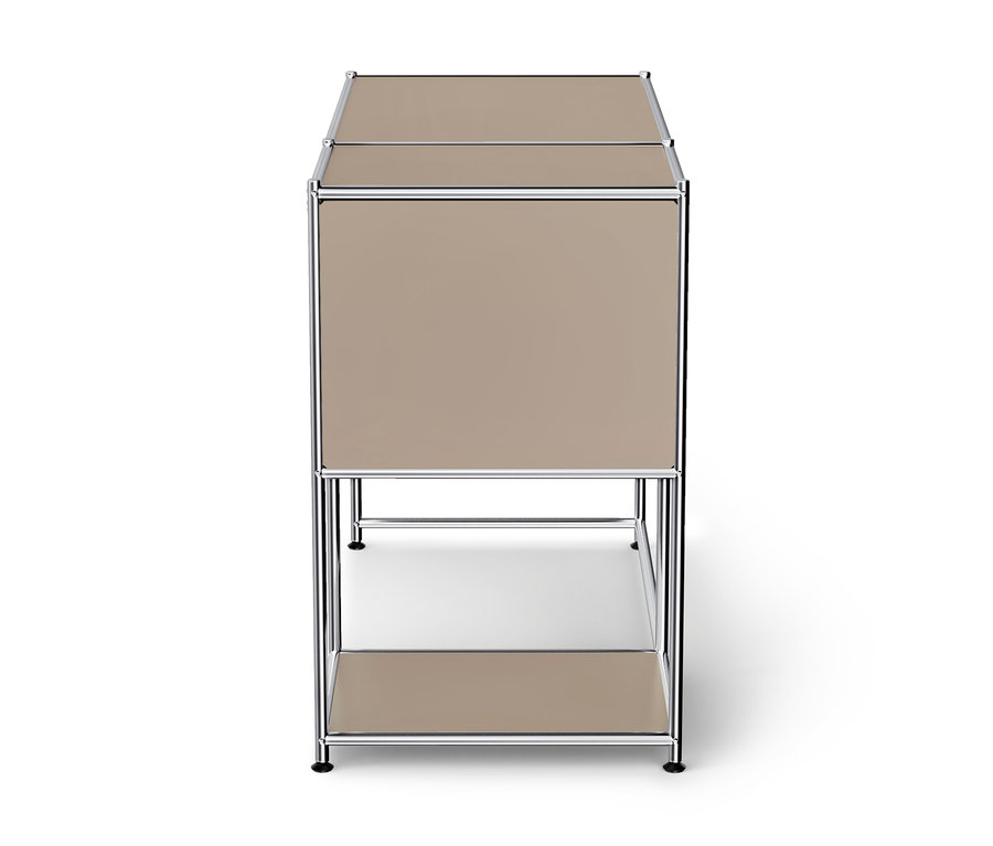 Meuble modulaire beige avec un cadre chromé, comprenant une section supérieure fermée et une étagère inférieure ouverte, sur fond blanc.