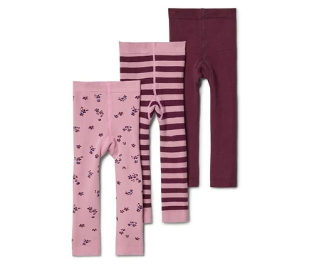 Trois leggings pour enfants superposés: un rose clair à motifs floraux, un rose clair rayé et un bordeaux uni.