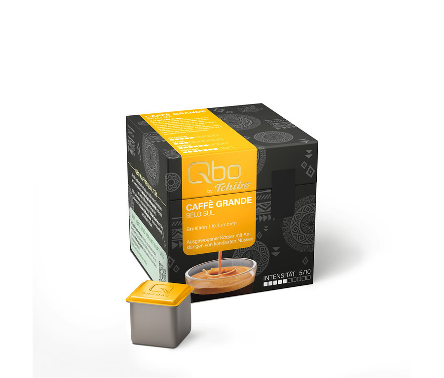 Boîte gris foncé de capsules de café Qbo Caffè Grande BELO SUL avec des accents jaunes, une capsule individuelle devant et une coupelle de café. Intensité 5/10, avec des notes de noix confites.