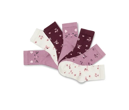 Sept paires de chaussettes pour enfant disposées en éventail, incluant des chaussettes violet clair avec des visages de chats et des chaussettes crème et violet foncé à motifs floraux.