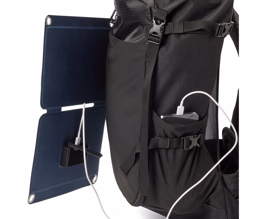 Sac à dos noir avec panneau solaire connecté à un téléphone portable par un câble blanc.