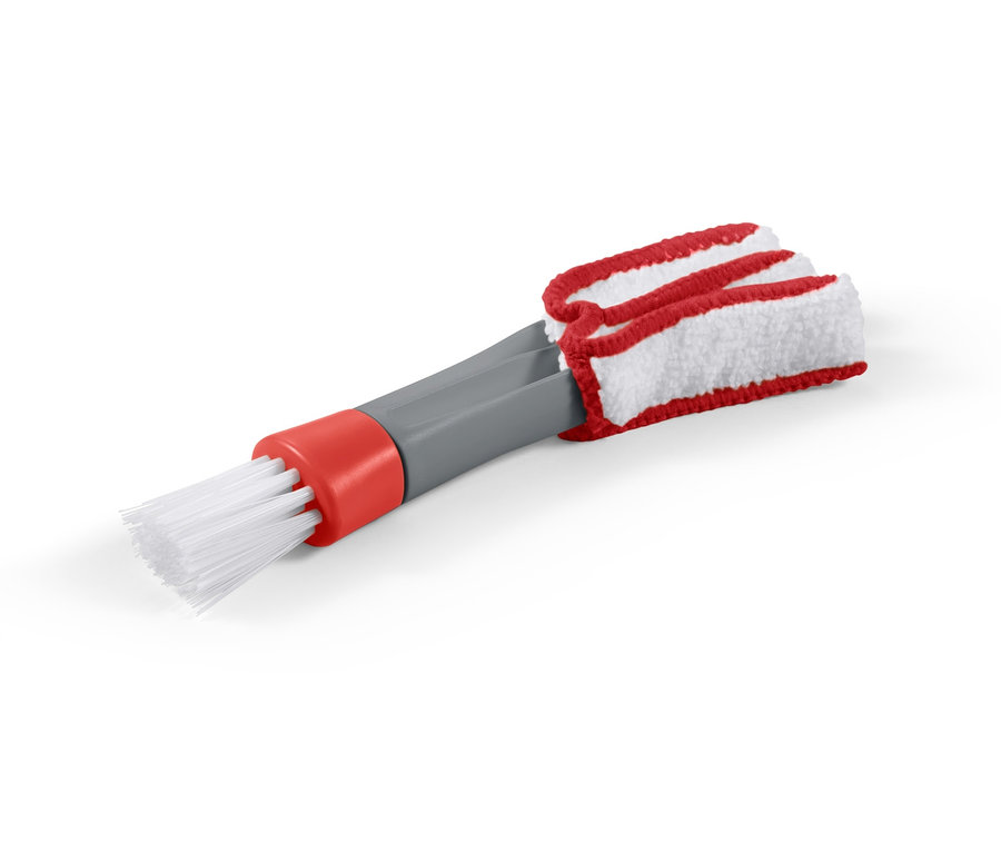 Gros plan d'une brosse de nettoyage 2 en 1 avec des poils blancs et une tête à poussière en tissu rouge et blanc.