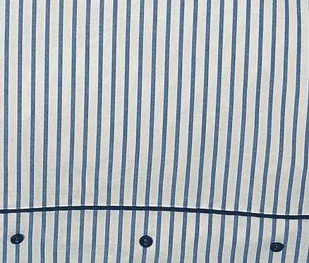 Gros plan sur une parure de lit en percale à rayures bleues avec des boutons.