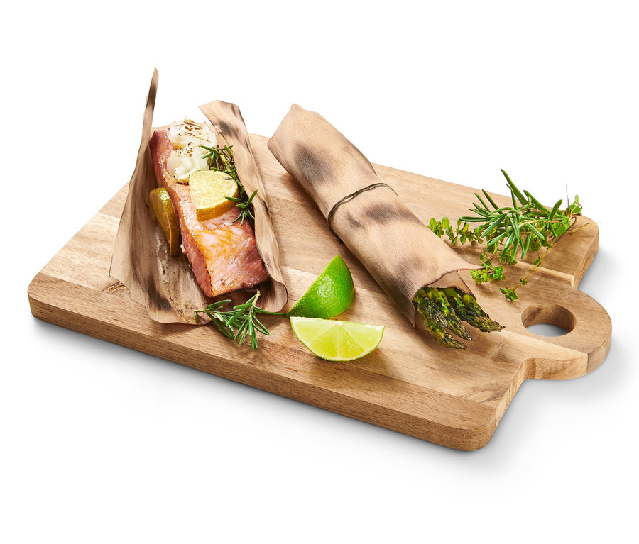 Saumon et asperges sur une planche à découper avec des papillotes en bois de hêtre.