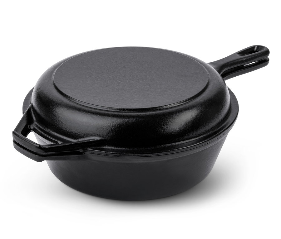 Une cocotte et poêle 2 en 1 en fonte noire avec couvercle sur fond blanc.