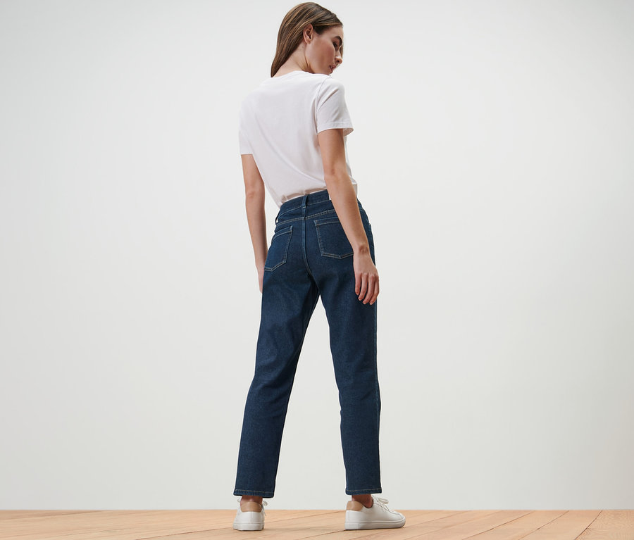 Une femme, vue de dos, porte un jean droit – Fit « Juna » et un t-shirt blanc.