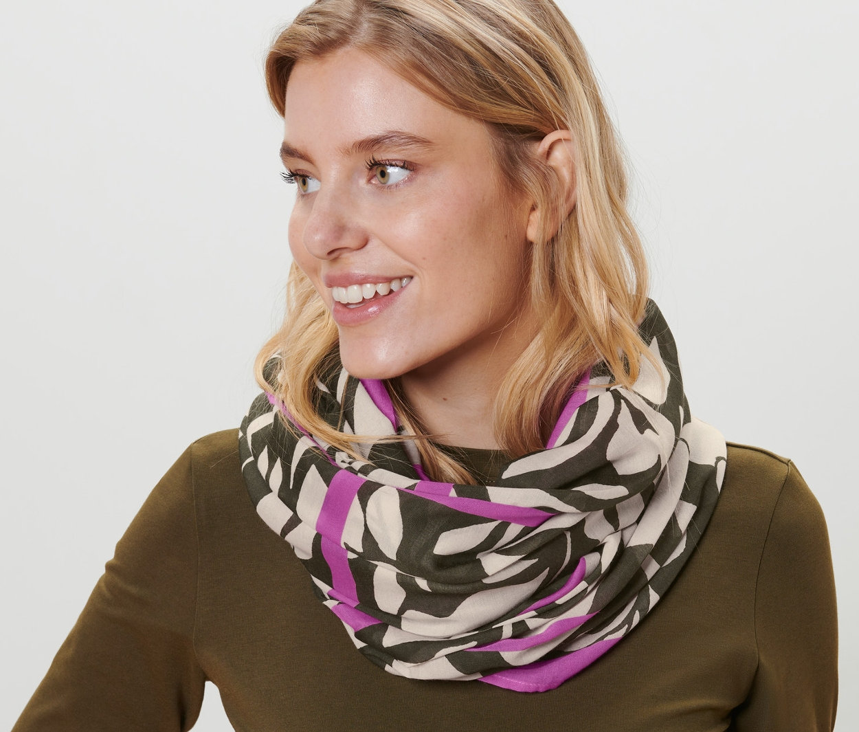 Femme blonde portant un foulard loop imprimé.
