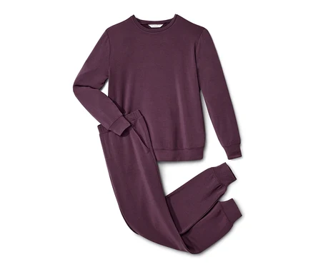 Un tenue d’intérieur violet repose sur un fond blanc.