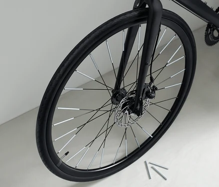 Gros plan sur un vélo noir avec 36 réflecteurs de rayons sur les rayons.