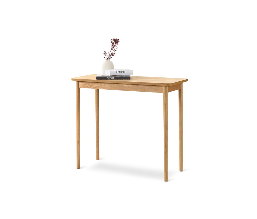 Sur une console en bois clair, il y a deux livres et un vase avec des fleurs.