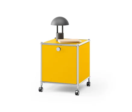 Table d’appoint en métal jaune « CN3 » avec abattant sur laquelle reposent une lampe grise et un livre.