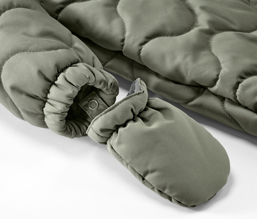 Gros plan sur une combinaison d’hiver olive pour bébé.