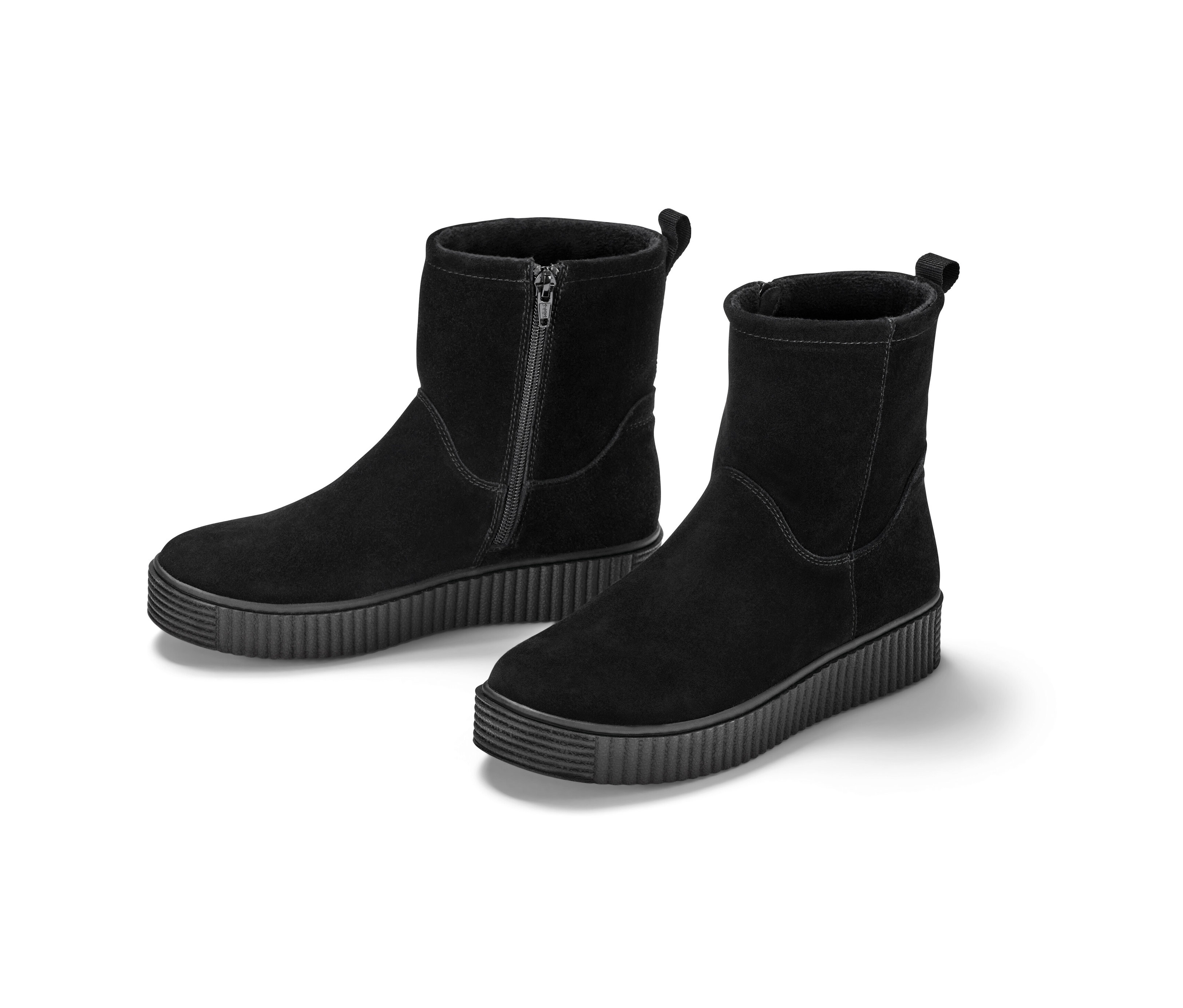 Deux bottines en cuir velours noires sur fond blanc.