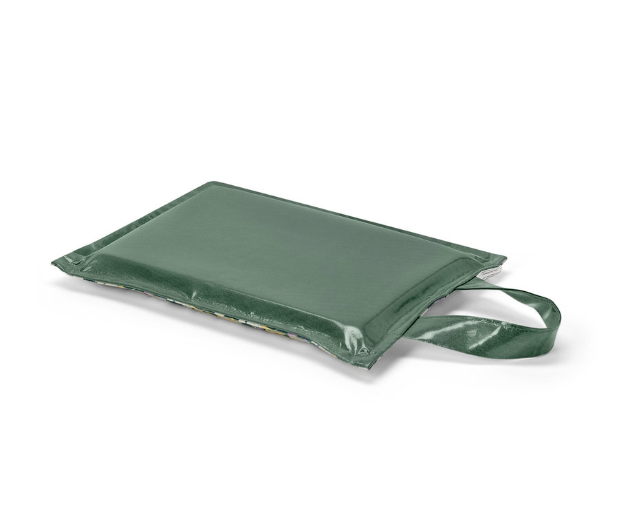 Un coussin pour genoux vert repose sur un fond blanc.