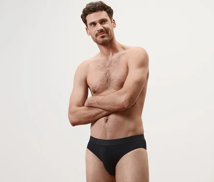 Homme les bras croisés portant 4 slips noirs