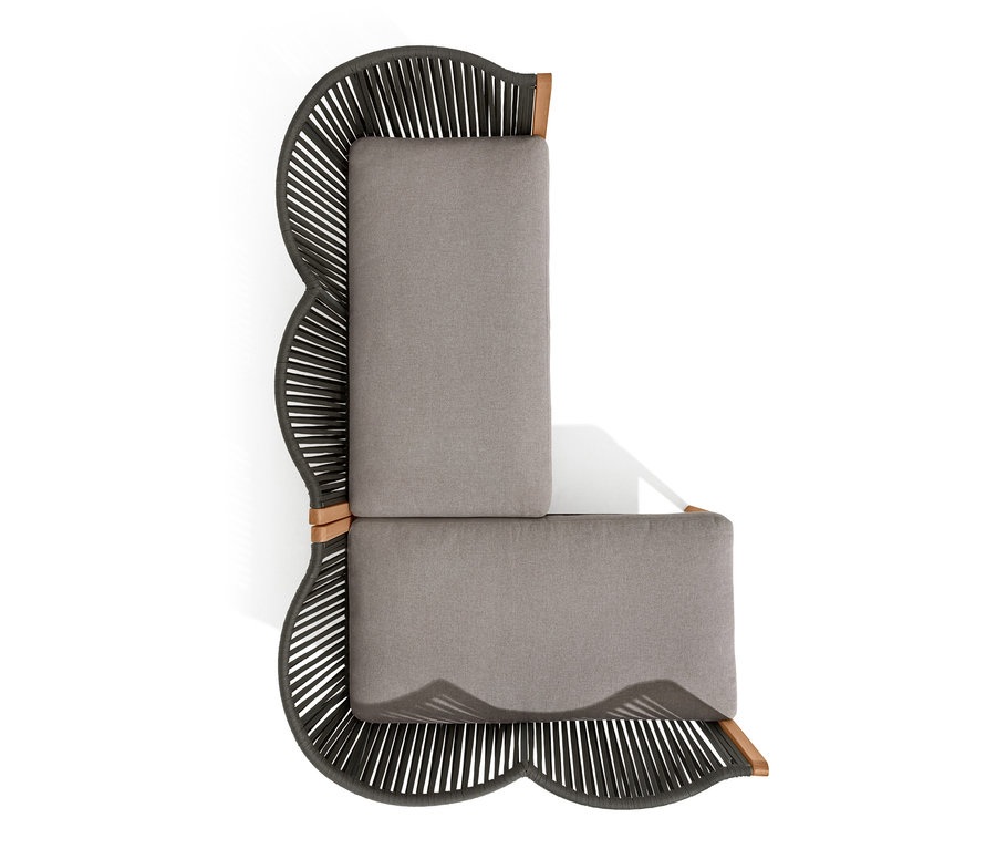 Vue de dessus d'un coin lounge avec tressage textile et coussins gris.