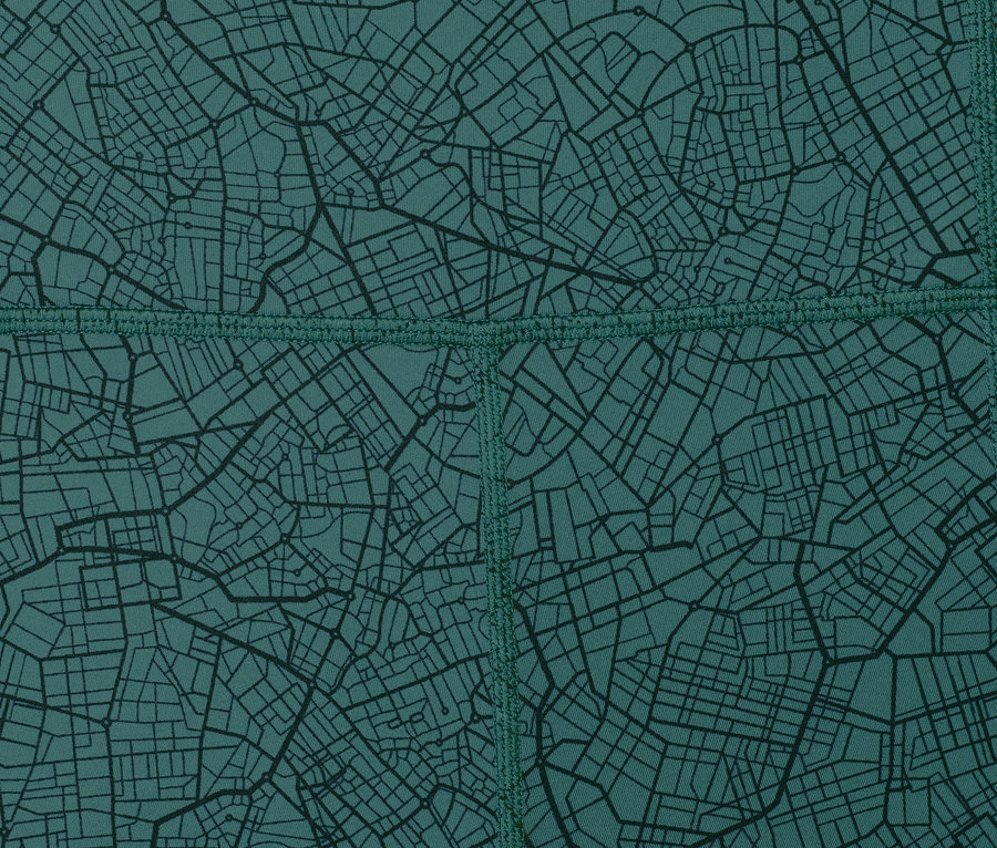 Gros plan sur un legging de sport avec un fond vert foncé et un motif de carte noir.