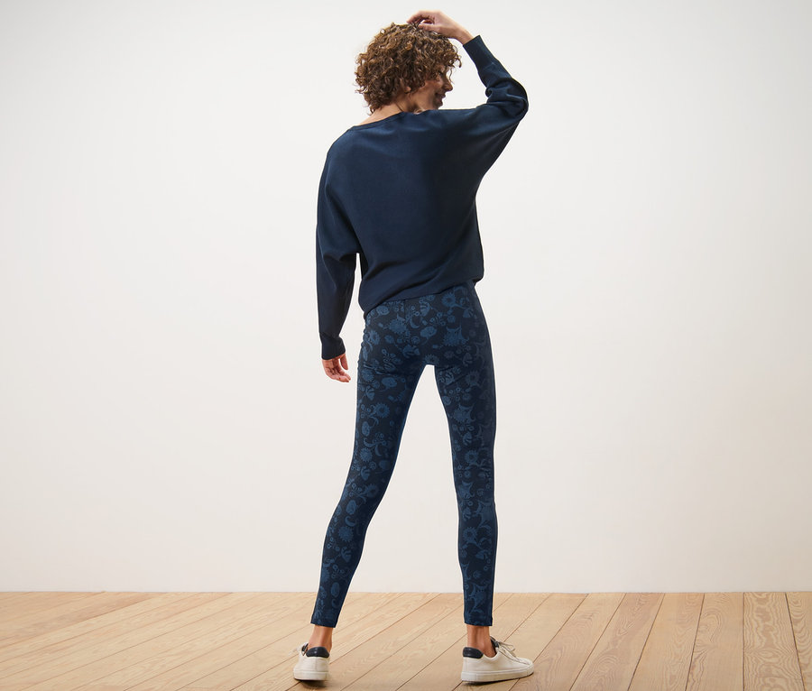 Femme vue de dos portant un legging bleu imprimé.