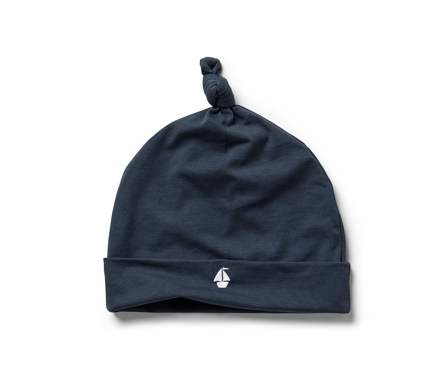 Bonnet de bébé bleu marine avec symbole de voilier, faisant partie d'un ensemble pour bébé 3 pièces.