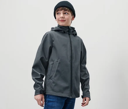 Garçon portant un bonnet noir et une veste en softshell pour enfant.