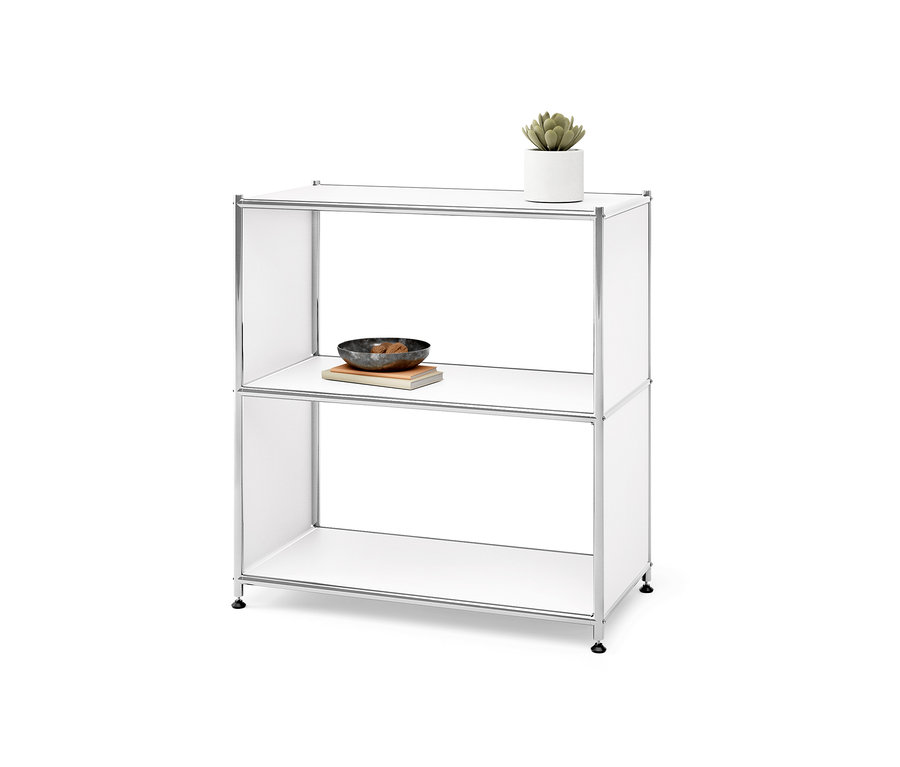 Étagère en métal « CN3 » à 2 compartiments. Un pot de fleurs sur l'étagère supérieure, un bol sur un livre sur l'étagère inférieure.