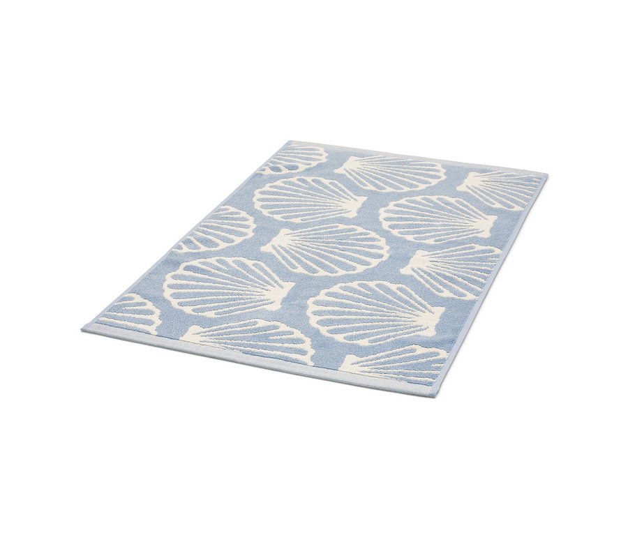 Tapis de douche bleu clair avec motif de coquillages en relief.