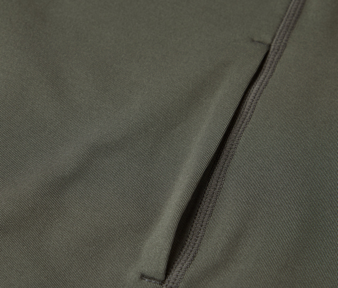 Gros plan d'un tissu vert olive avec une poche zippée.