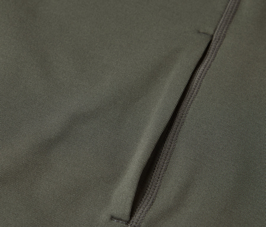 Gros plan d'un tissu vert olive avec une poche zippée.