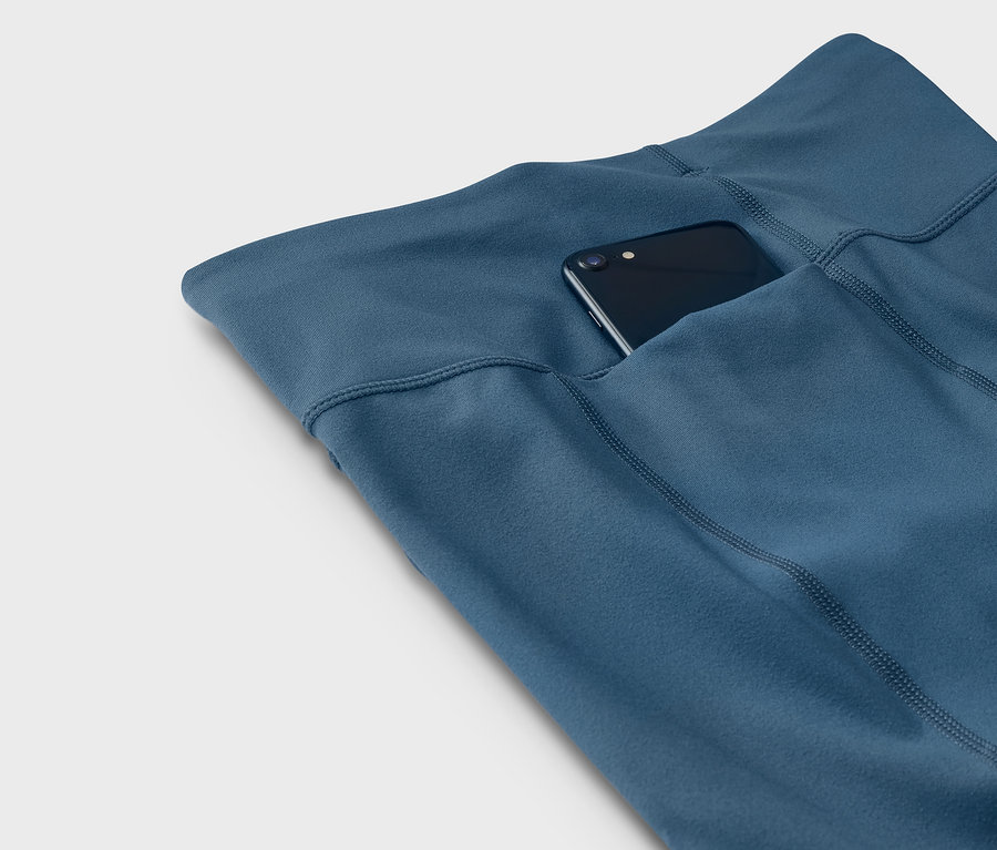 Leggings bleus avec un téléphone dans la poche.