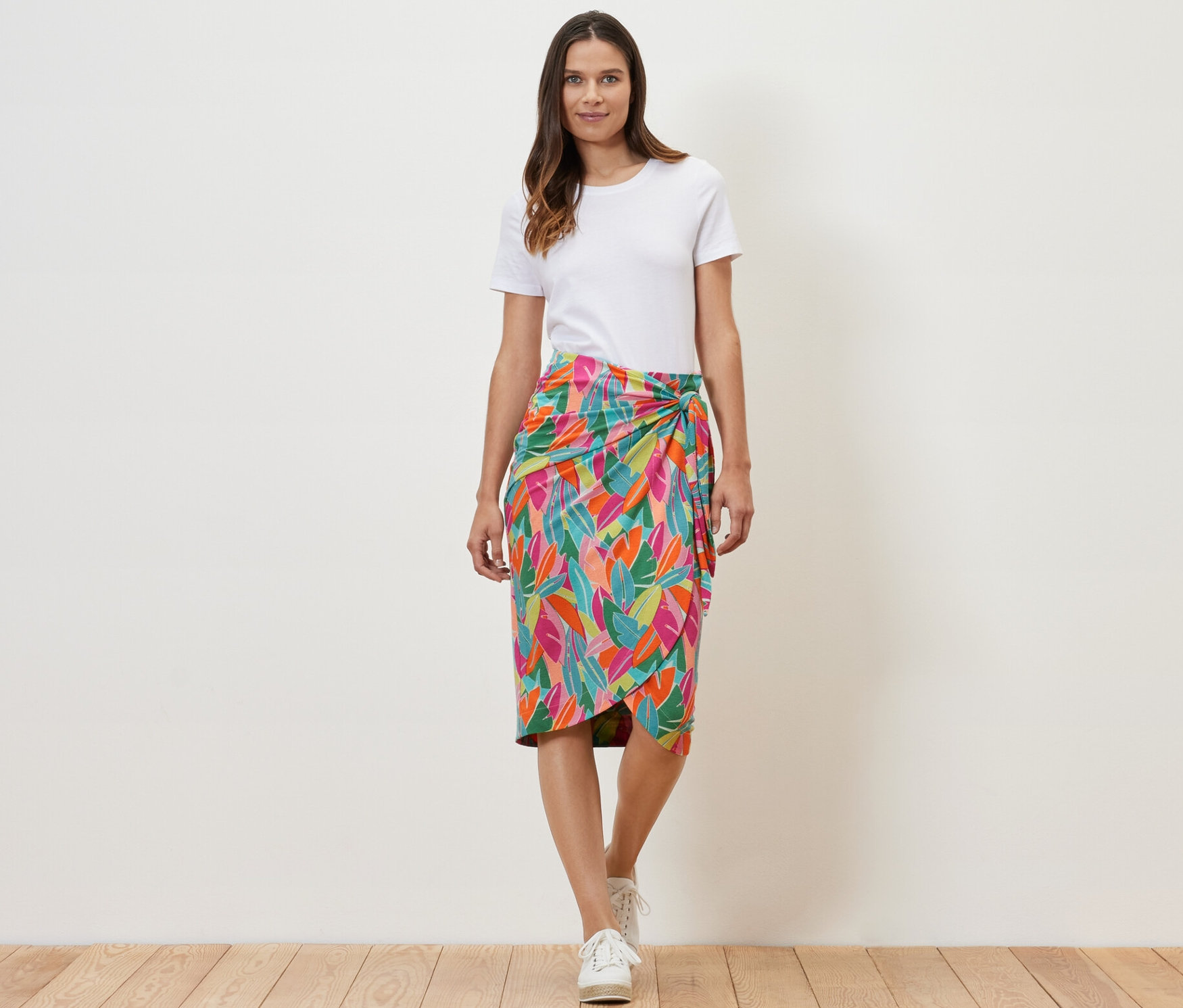 Femme portant une jupe portefeuille en jersey avec un imprimé de feuilles.