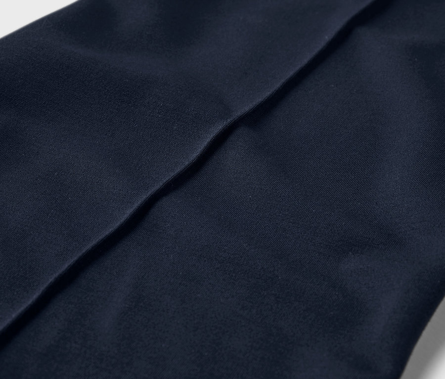 Gros plan sur un pantalon en jersey avec passepoil.