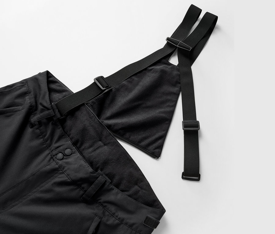 Gros plan sur un pantalon noir à bretelles et sangles réglables.