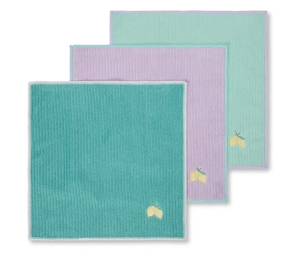 Trois serviettes de table en tissu colorées avec une broderie de citron dans le coin inférieur gauche.