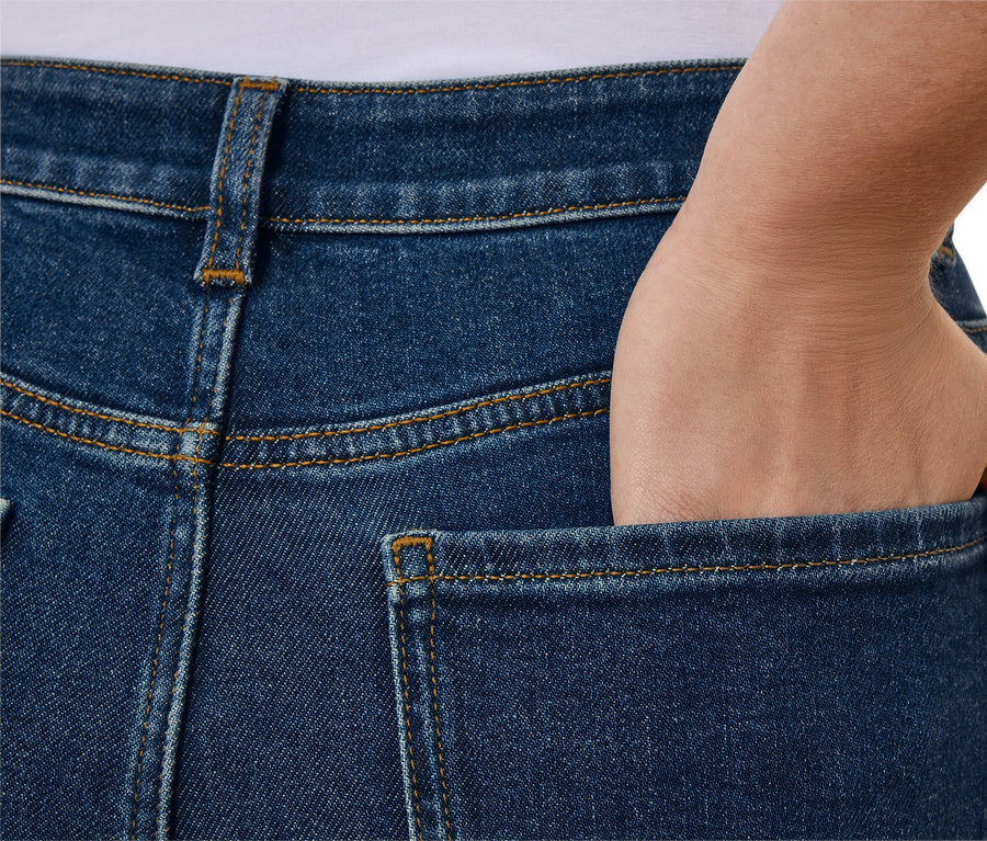 Gros plan sur l'arrière d'un jean bleu avec une main dans la poche.