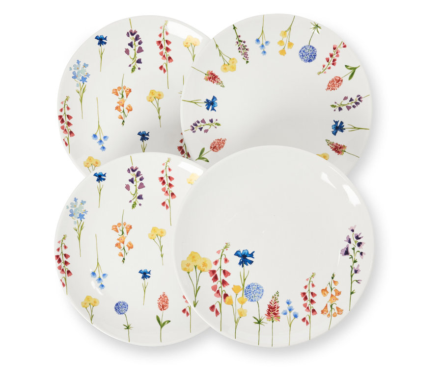 Quatre assiettes à dessert décorées de fleurs sont posées les unes sur les autres.