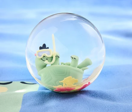 Une tortue verte avec des lunettes de plongée et un tuba à l'intérieur d'une boule transparente sur un fond bleu. Produit: Balle rebondissante XXL