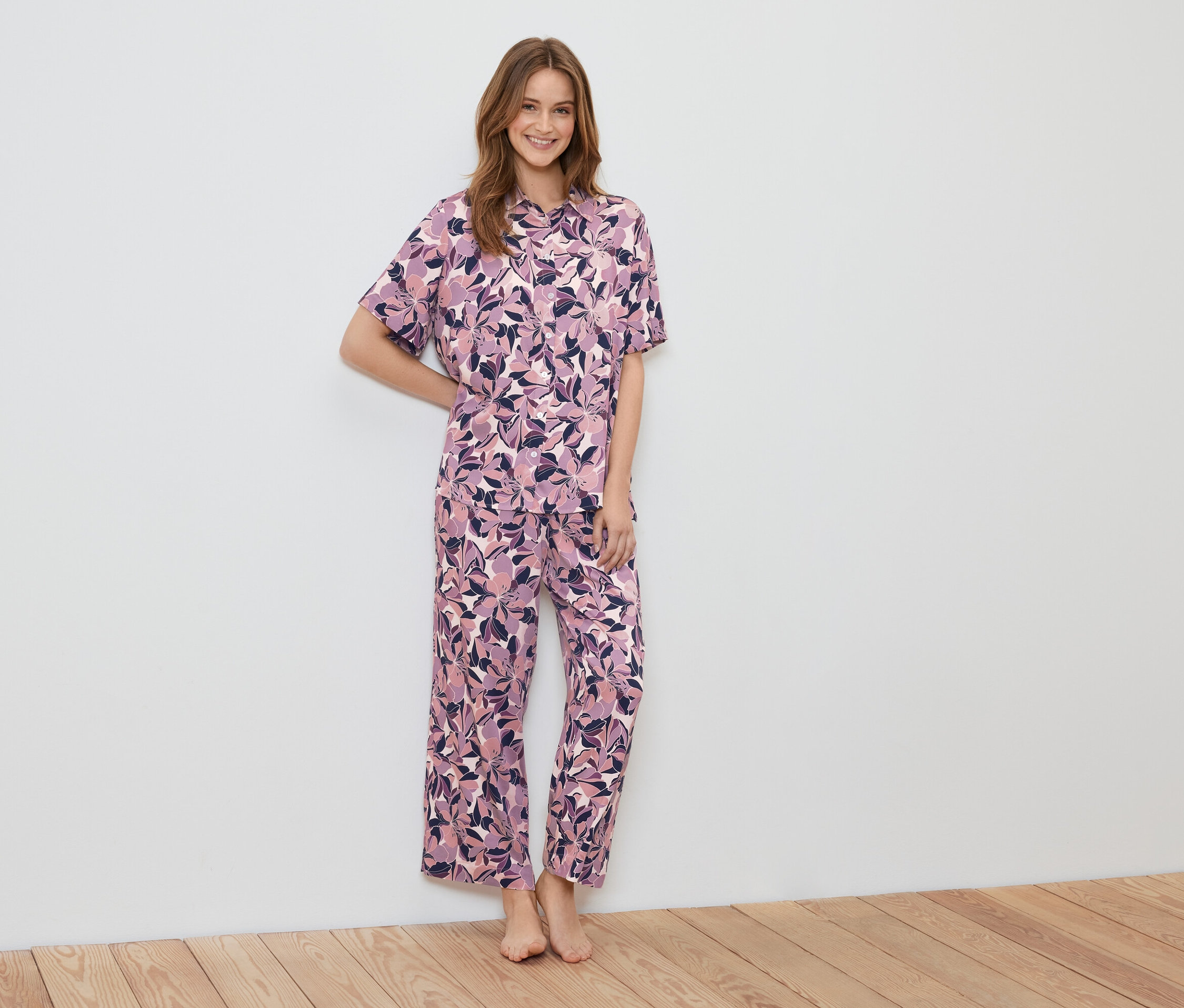 Une femme debout portant un pyjama à motifs floraux.