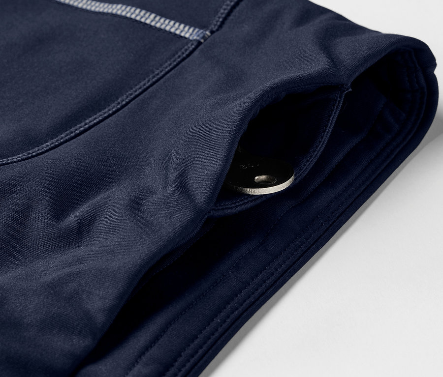 Gros plan sur un pantalon de sport bleu marine avec une poche et une clé à l'intérieur.